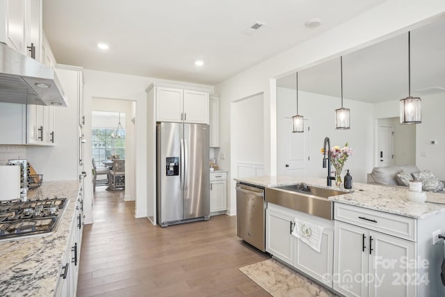 kitchen featuring pendant lighting, sink, light hardwood / wood-style flooring, white cabinetry, and stainless steel appliances