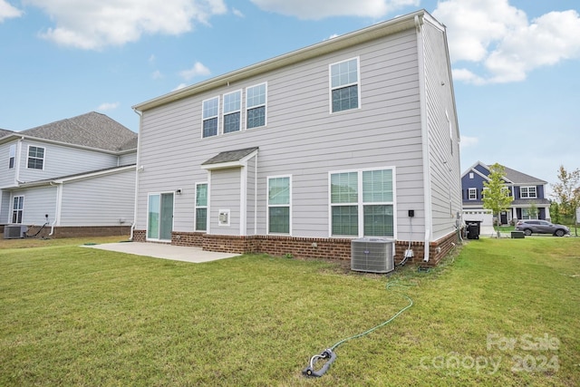 back of property with cooling unit, a yard, and a patio area