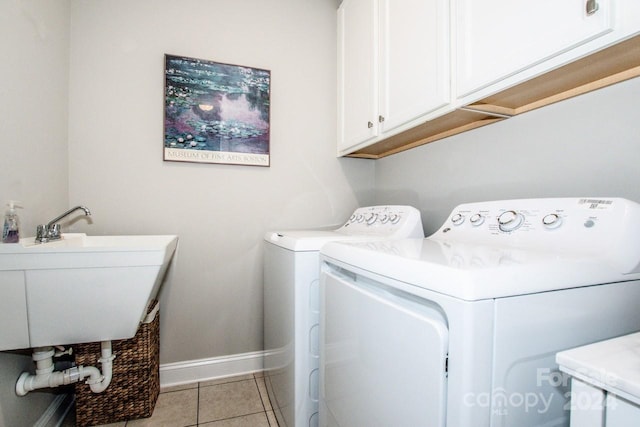 washroom featuring cabinets, sink, light tile patterned floors, and washer and dryer