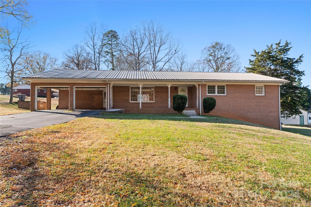 ranch-style home featuring a front lawn and a carport