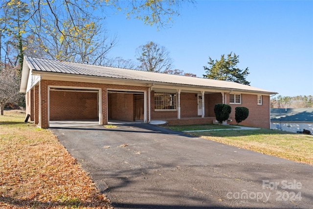 ranch-style house with a porch, a garage, and a front yard