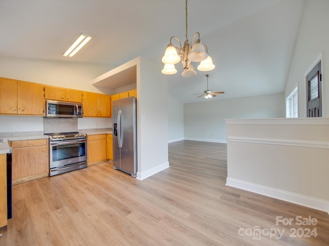 kitchen featuring light wood-type flooring, appliances with stainless steel finishes, pendant lighting, vaulted ceiling, and ceiling fan with notable chandelier