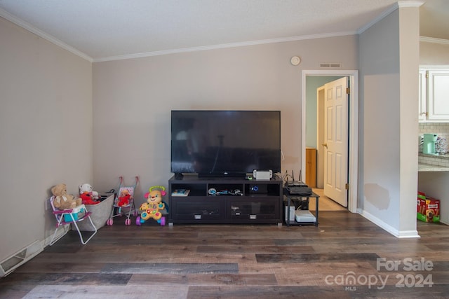 living area with crown molding, wood finished floors, visible vents, and baseboards