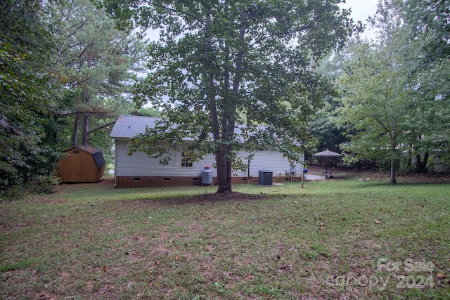 view of yard featuring central AC unit and a storage unit