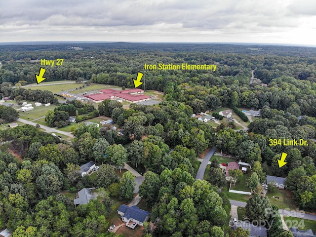 birds eye view of property featuring a wooded view
