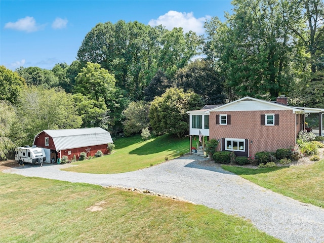 view of front of house with an outdoor structure and a front lawn