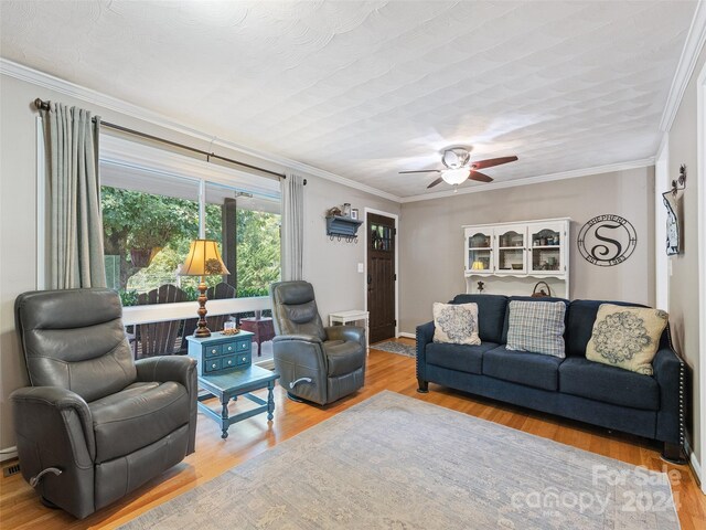 living room featuring ceiling fan, light hardwood / wood-style flooring, and crown molding