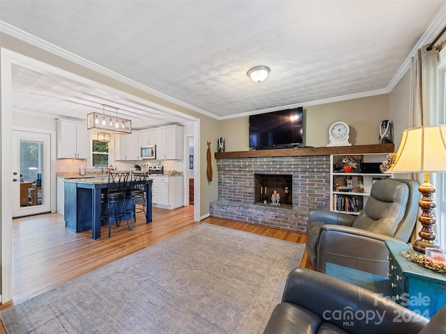 living room with ornamental molding, light hardwood / wood-style floors, and a fireplace