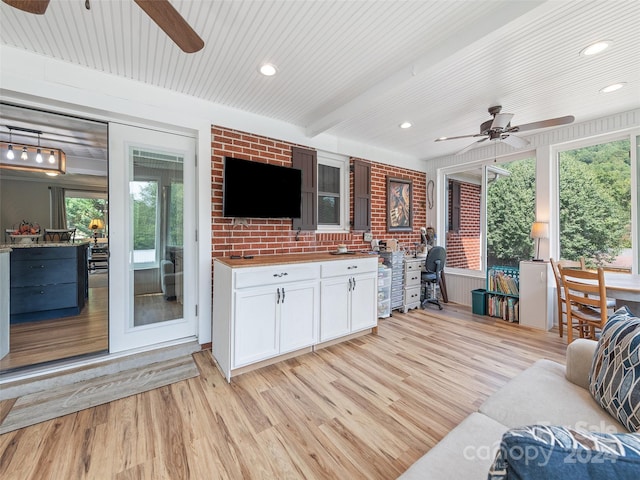 interior space with ceiling fan, light wood-type flooring, and beam ceiling