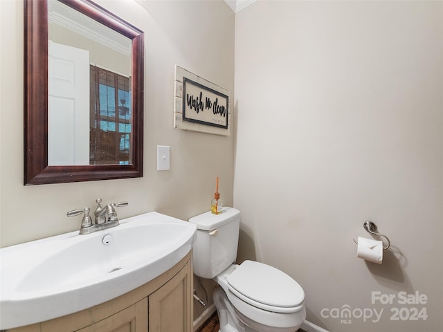 bathroom featuring vanity, crown molding, and toilet