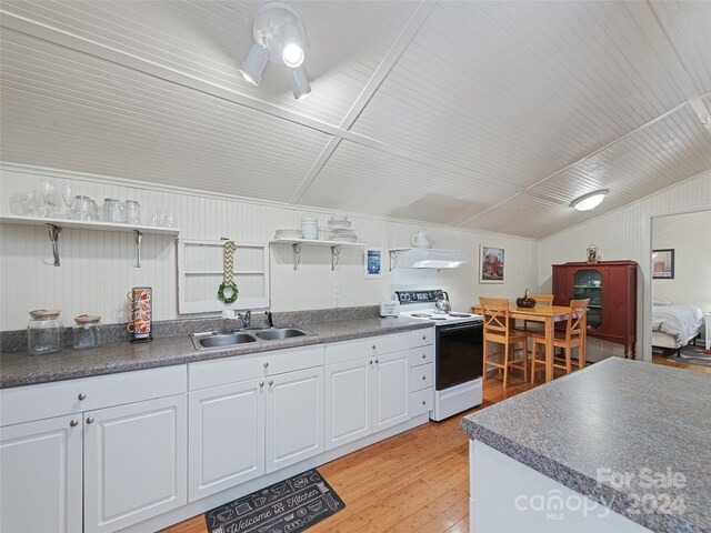 kitchen featuring light hardwood / wood-style floors, white cabinets, white electric stove, wooden walls, and sink