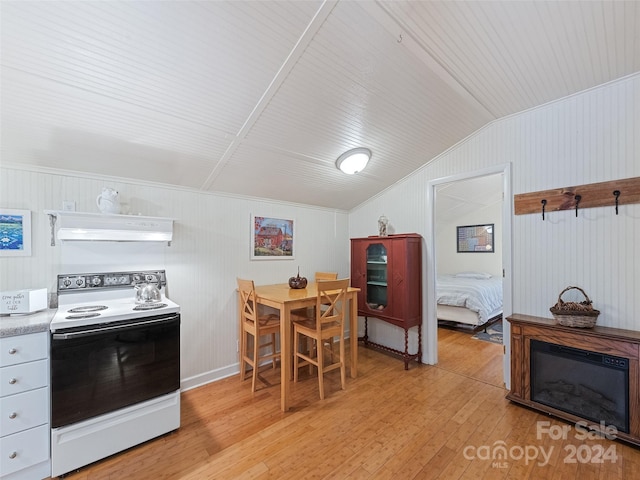 kitchen featuring electric range oven, wood walls, ventilation hood, lofted ceiling, and light hardwood / wood-style flooring