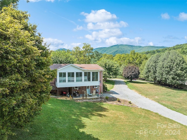 view of front facade featuring a front lawn and a mountain view