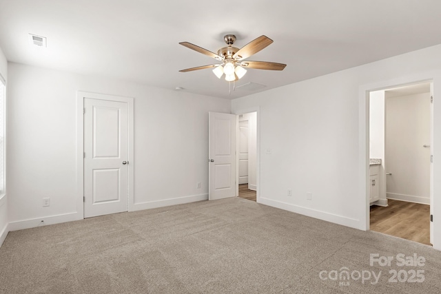 unfurnished bedroom featuring light carpet, connected bathroom, and ceiling fan