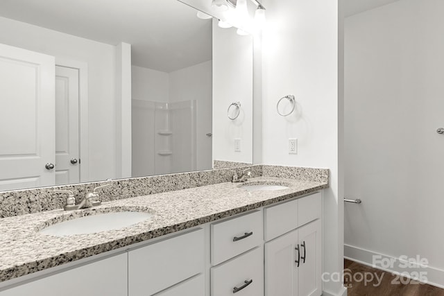 bathroom featuring a shower, hardwood / wood-style floors, and vanity