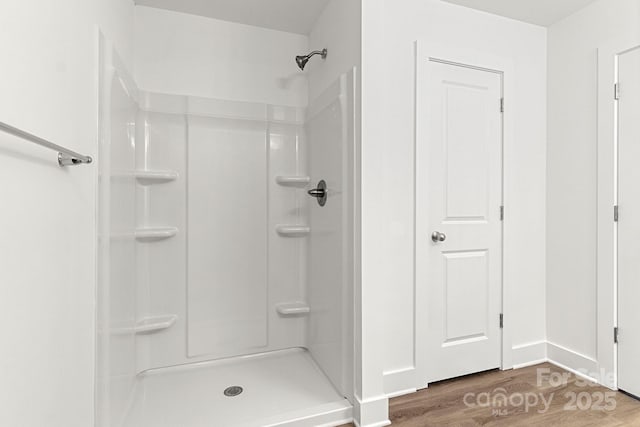 bathroom with a shower and hardwood / wood-style floors