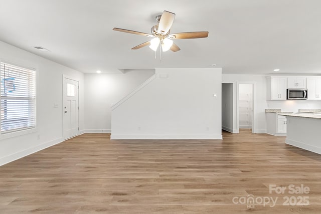 unfurnished living room featuring ceiling fan and light hardwood / wood-style floors