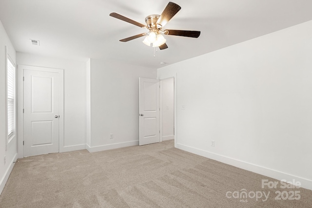 carpeted spare room featuring ceiling fan