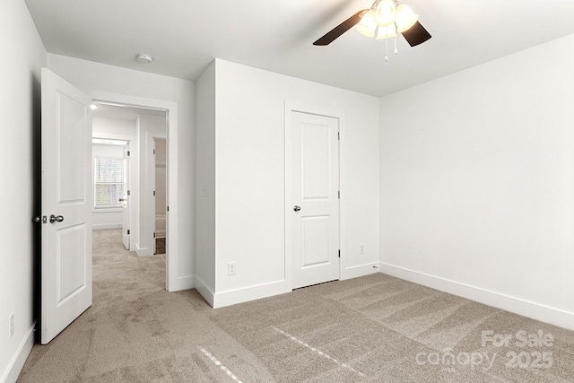 unfurnished bedroom featuring ceiling fan, light carpet, and a closet