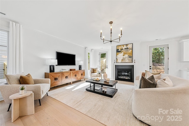 living room with light hardwood / wood-style flooring and an inviting chandelier