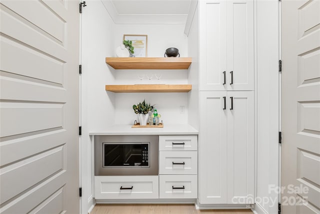 bar with crown molding and white cabinets