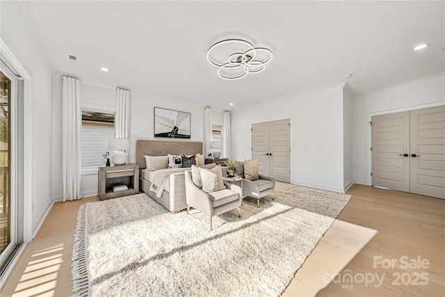 bedroom with light hardwood / wood-style floors and ornamental molding