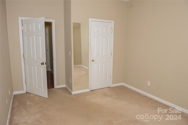 unfurnished bedroom with light colored carpet