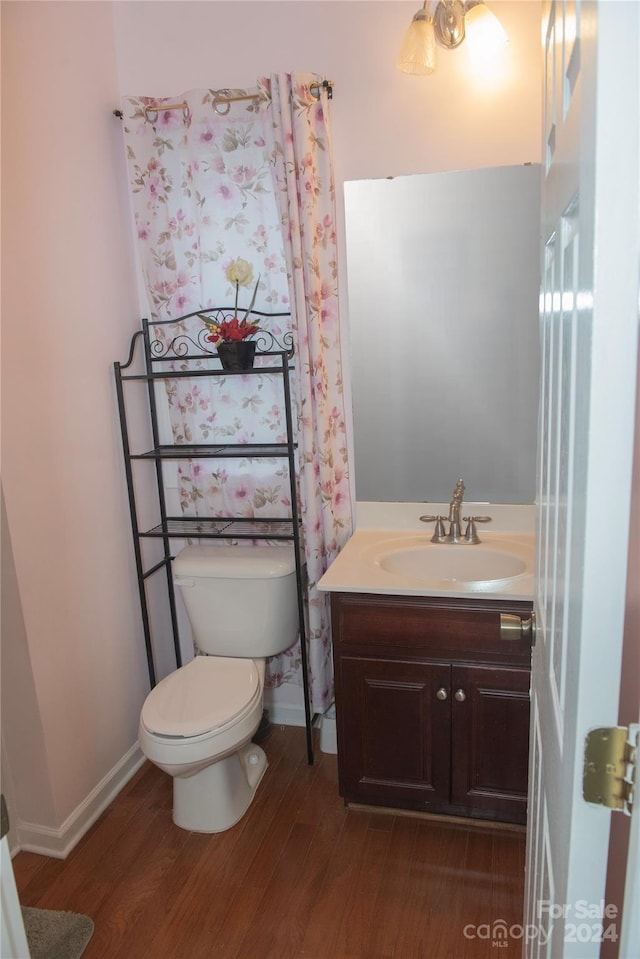 bathroom with hardwood / wood-style flooring, vanity, and toilet