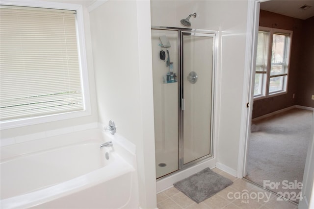 bathroom featuring tile patterned floors and separate shower and tub