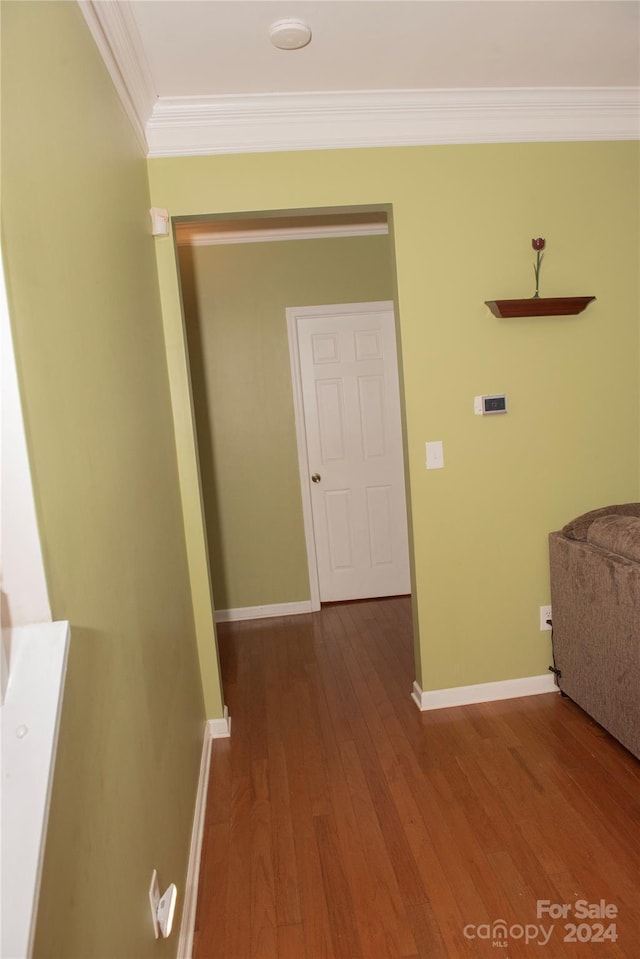 hallway featuring wood-type flooring and ornamental molding