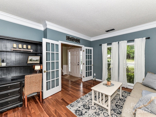 living room featuring a textured ceiling, built in desk, crown molding, and dark hardwood / wood-style flooring