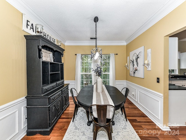 dining area featuring a textured ceiling, crown molding, dark hardwood / wood-style floors, and sink