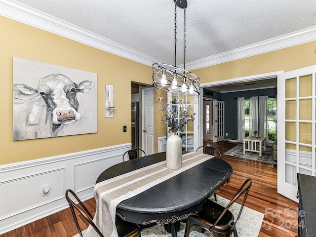 dining space with a textured ceiling, dark hardwood / wood-style floors, and crown molding