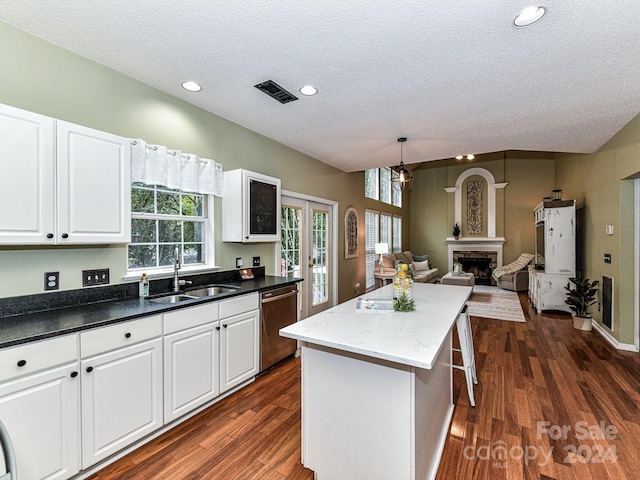 kitchen with dishwasher, sink, white cabinets, a kitchen island, and dark hardwood / wood-style flooring