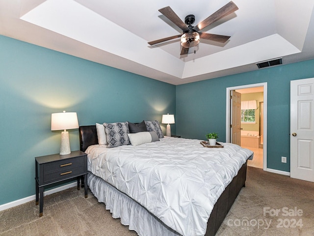 bedroom featuring carpet, ceiling fan, a raised ceiling, and ensuite bathroom