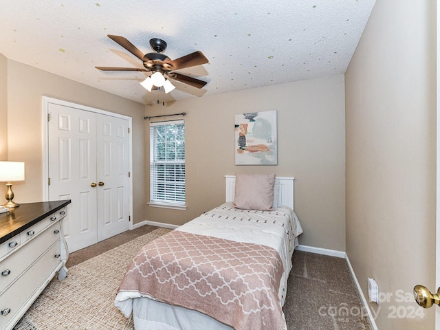 carpeted bedroom featuring a textured ceiling, ceiling fan, and a closet