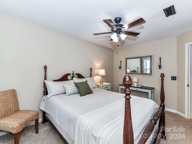 carpeted bedroom featuring a textured ceiling and ceiling fan