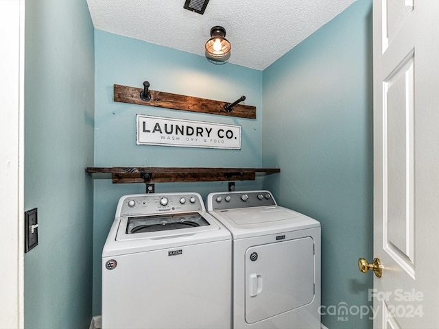 washroom with a textured ceiling and independent washer and dryer