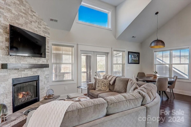 living room featuring a wealth of natural light, a fireplace, high vaulted ceiling, and dark wood-type flooring