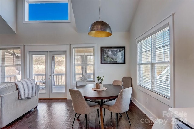 dining room featuring vaulted ceiling, plenty of natural light, and dark hardwood / wood-style floors