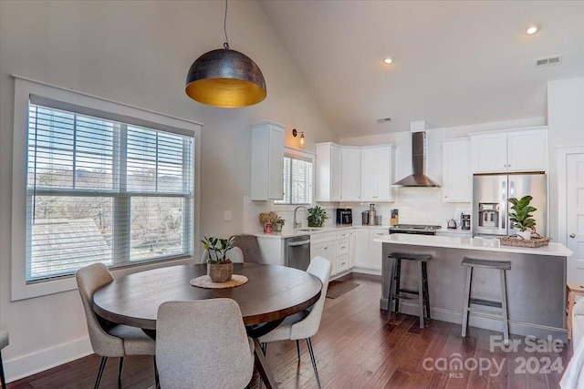 dining space featuring plenty of natural light, high vaulted ceiling, dark wood-type flooring, and sink