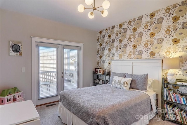 bedroom with carpet flooring, a notable chandelier, and access to outside