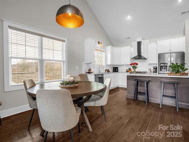 dining area with high vaulted ceiling, dark hardwood / wood-style flooring, and sink