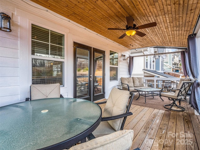 wooden terrace with an outdoor living space and ceiling fan