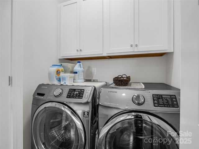 clothes washing area with separate washer and dryer and cabinets