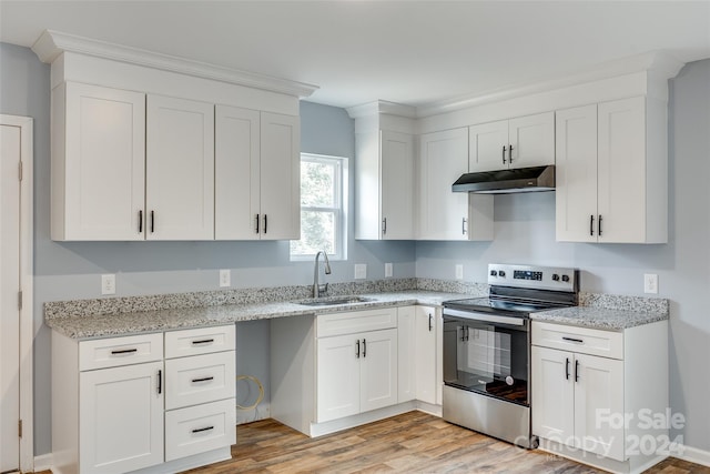 kitchen with stainless steel electric range, light hardwood / wood-style floors, white cabinetry, and sink