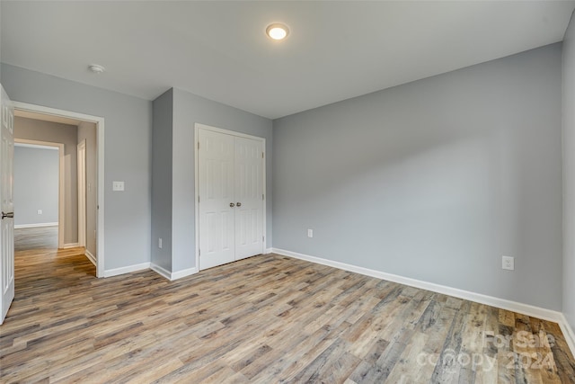 unfurnished bedroom with a closet and light hardwood / wood-style flooring