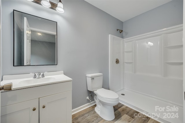 bathroom featuring walk in shower, hardwood / wood-style floors, vanity, and toilet