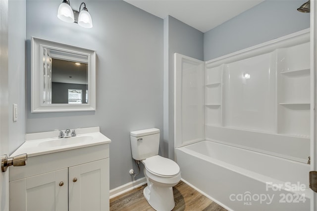 full bathroom with hardwood / wood-style floors, bathing tub / shower combination, vanity, and toilet