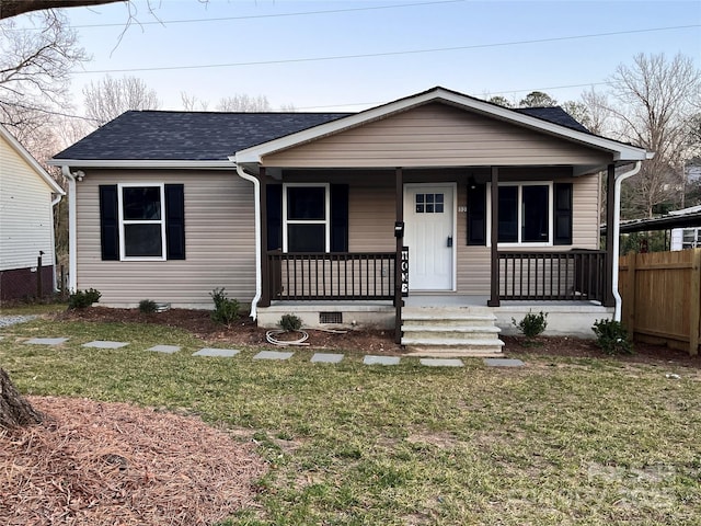 bungalow-style house with roof with shingles, crawl space, covered porch, fence, and a front lawn